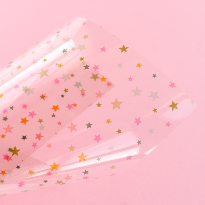 Plástico transparente com estrelas coloridas sobre fundo rosa