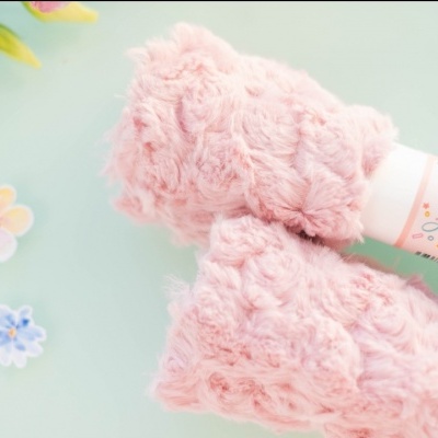 Painéis de pele rosa claro com textura macia e etiquetas, sobre mesa azul com flores decorativas.