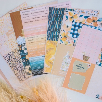 Folhas decorativas de papel com vários padrões florais e textuais sobre superfície branca