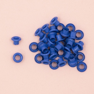 Ilhóses de plástico azuis sobre fundo cor de rosa claro