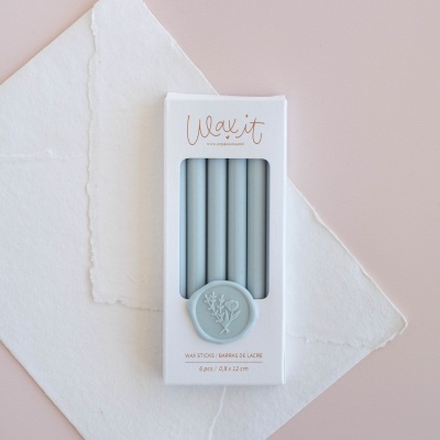 Conjunto de palitos de cera cinza em embalagem branca com selo cinza decorado
