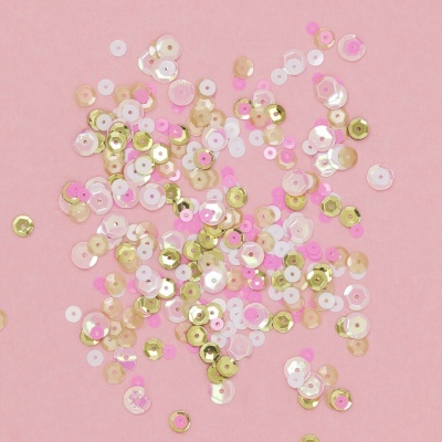 Lantejoulas coloridas espalhadas sobre fundo rosa