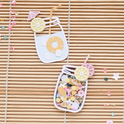 Ornamentos em papel em forma de copos de bebida com detalhes coloridos sobre ripas de madeira clara