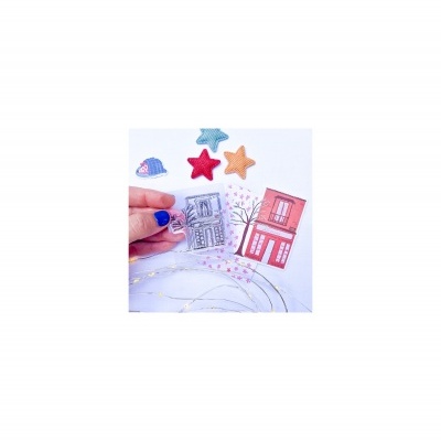 Adesivos de prédios, estrelas de tecido e uma árvore desenhada em fundo branco