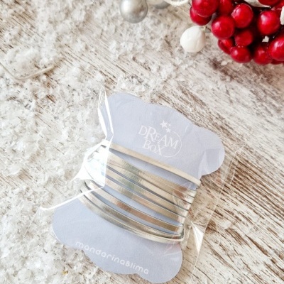 Conjunto de pulseiras douradas em cartão branco com texto DREAM Box