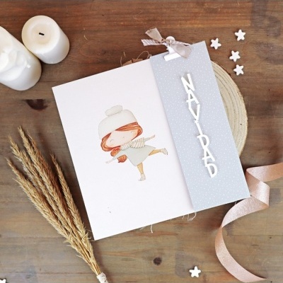 Cartão de felicitações com etiqueta cinzenta e texto 'NAVIDAD' e desenho de menina patinando