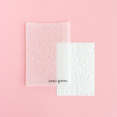 Separadores de papel com padrão floral em relevo em fundo rosa