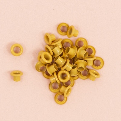 Conjunto de ilhós amarelos em plástico sobre fundo rosa