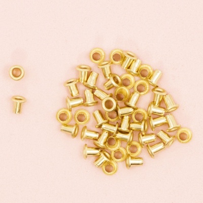 Vários ilhóses dourados pequenos sobre fundo rosa