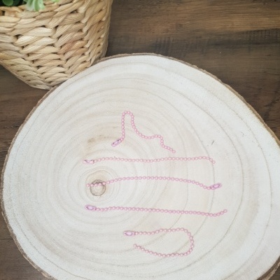 Colar cor de rosa em madeira clara com vaso e planta verde