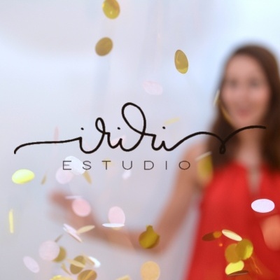 Logo iridi ESTUDIO com pessoa ao fundo e confetes dourados