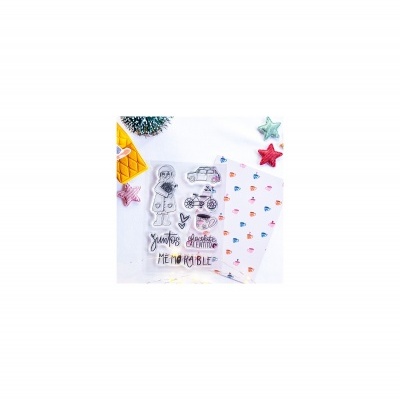 Conjunto de carimbos transparentes com desenhos e texto, papel decorativo com corações, e estrelas de tecido coloridas sobre fundo branco.
