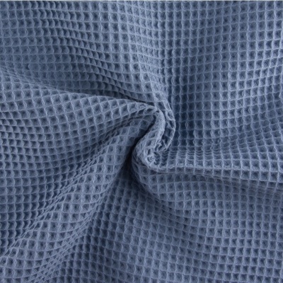 Tecido azul claro com padrão quadriculado tipo waffle e dobras ao centro