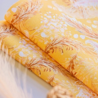 Tecido amarelo com padrão de penas