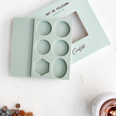 Moldes de silicone verde claro com seis cavidades em várias formas e embalagem azul claro