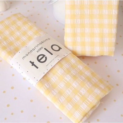 tecidos amarelos com padrão xadrez e etiqueta branca