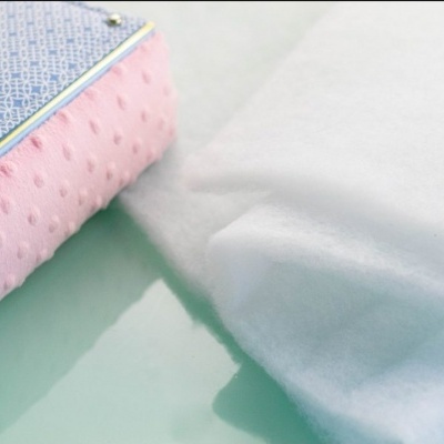 Amostras de tecido rosa e branco junto a caixa de amostras