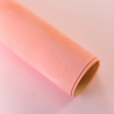Rolo de papel rosa claro em superfície plana