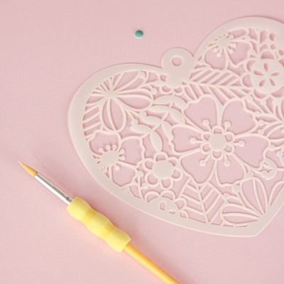 Stencil coração floral branco com pincele amarelo em fundo rosa