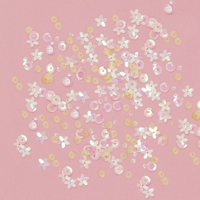 Sequins flores brancas e círculos perolados rosa e amarelos sobre fundo rosa