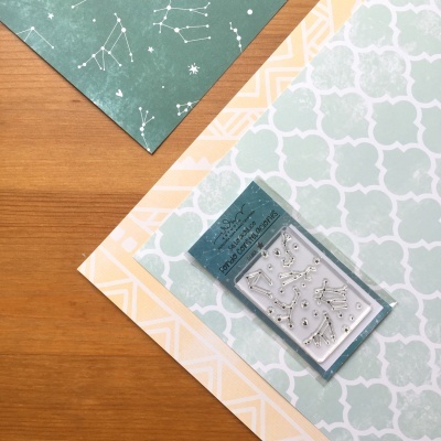 Elementos metálicos prateados em embalagem sobre papéis decorativos coloridos