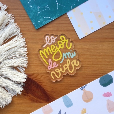 Autocolante colorido transparente em fundo de madeira com papéis decorativos e franjas de tecido