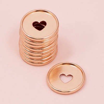Peças metálicas circulares douradas com recorte de coração