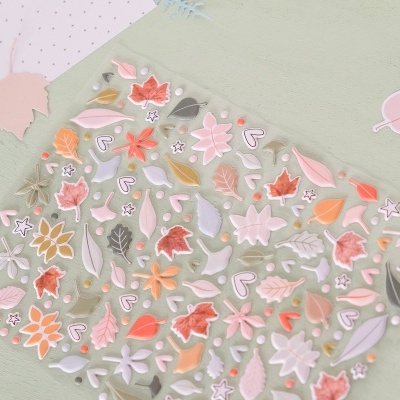 Saco plástico transparente com padrão floral colorido sobre superfície verde