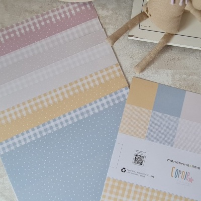 Conjunto de papéis decorativos com padrões em cores pastel e etiqueta com texto e código QR.
