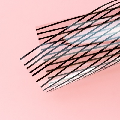 Papel transparente com linhas pretas sobre fundo rosa