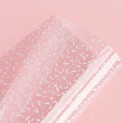 Película transparente com padrão de folhas brancas sobre fundo rosa