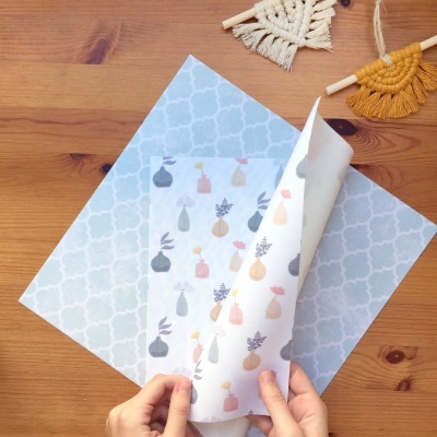 Folhas de papel decorativo com padrões coloridos em mesa de madeira