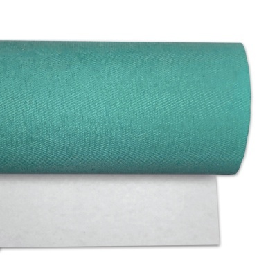 Rolo de tecido verde-azulado sobre superfície branca