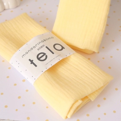 Conjunto de dois tecidos amarelos com faixa branca e texto preto, sobre fundo branco com pontos dourados