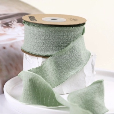 Rolo de fita decorativa verde claro com textura enrugada