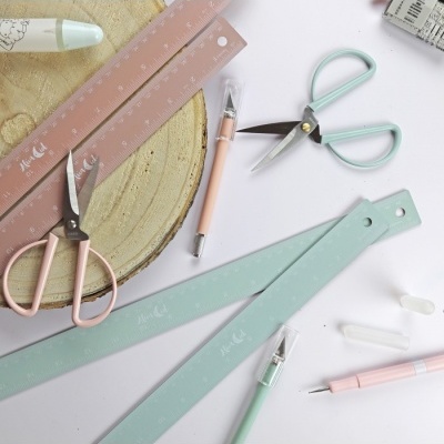 Material escolar colorido com réguas, tesouras e canetas em tons pastel