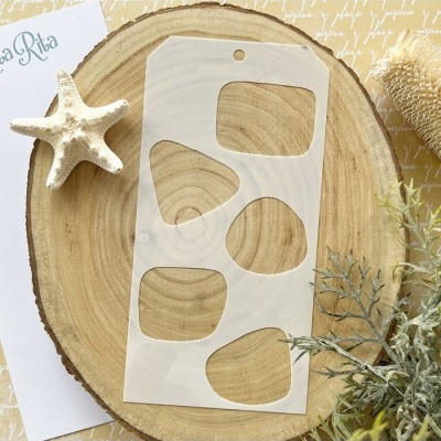 Molde plástico branco com recortes sobre disco de madeira com estrela do mar e vegetação seca