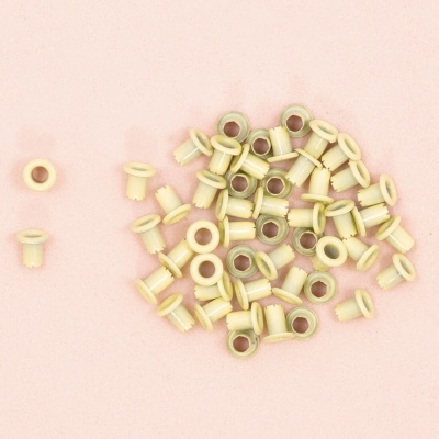 Conjunto de 50 ilhóses brancos para costura sobre fundo rosa