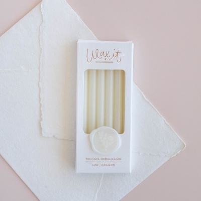 Caixa branca com bastões de parafina e texto em português e inglês