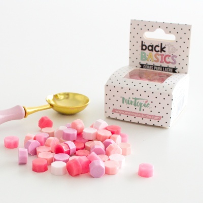 Pérolas coloridas para lacre com colher dourada e embalagem branca com pontos pretos