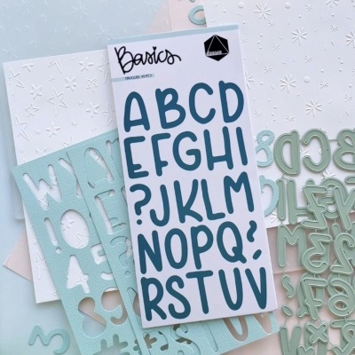 Conjunto de letras adesivas e moldes de letras verdes em fundo claro com flores e régua.