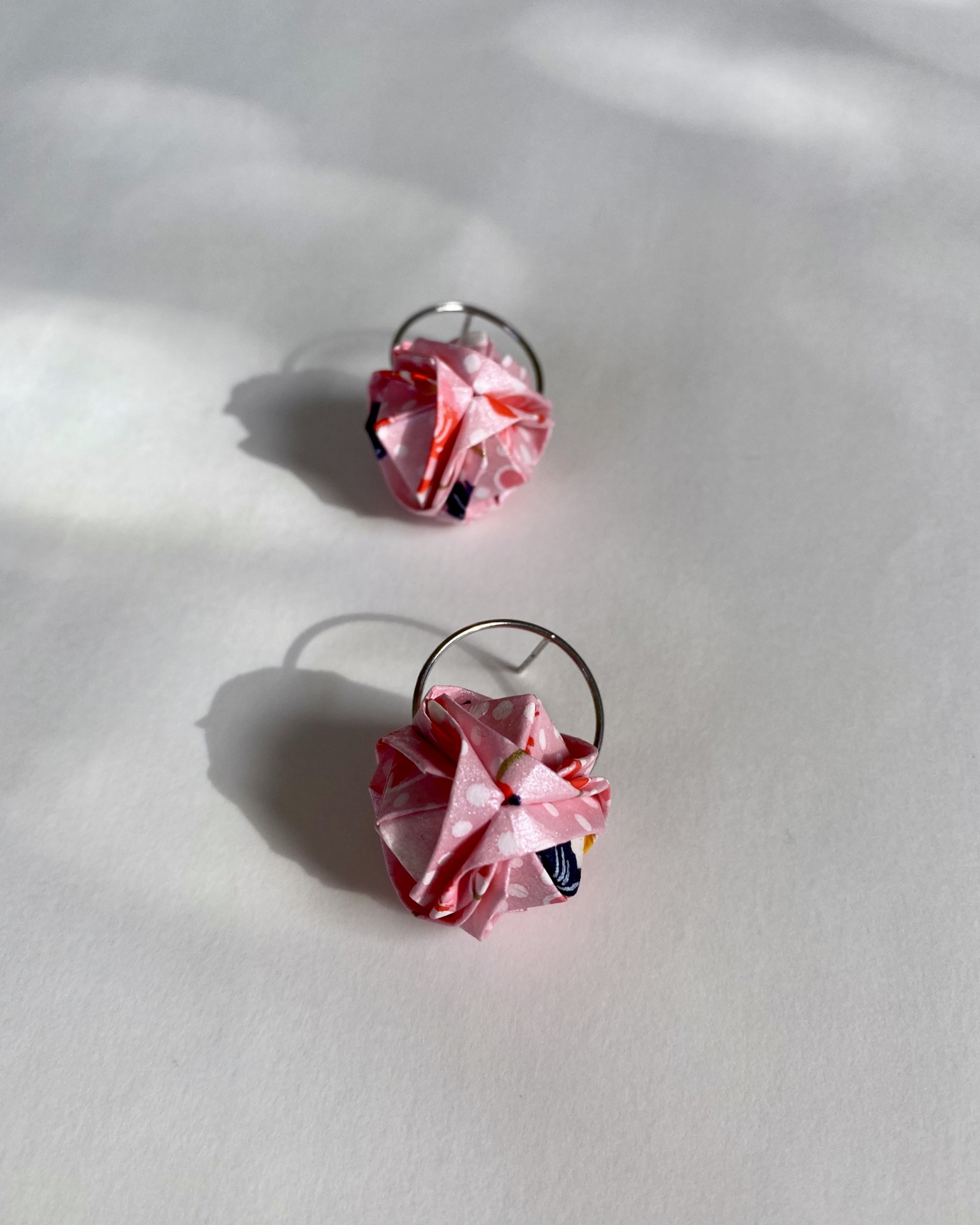 Brincos Barun Brincos com flores de tecido rosa e padrão floral sobre superfície branca