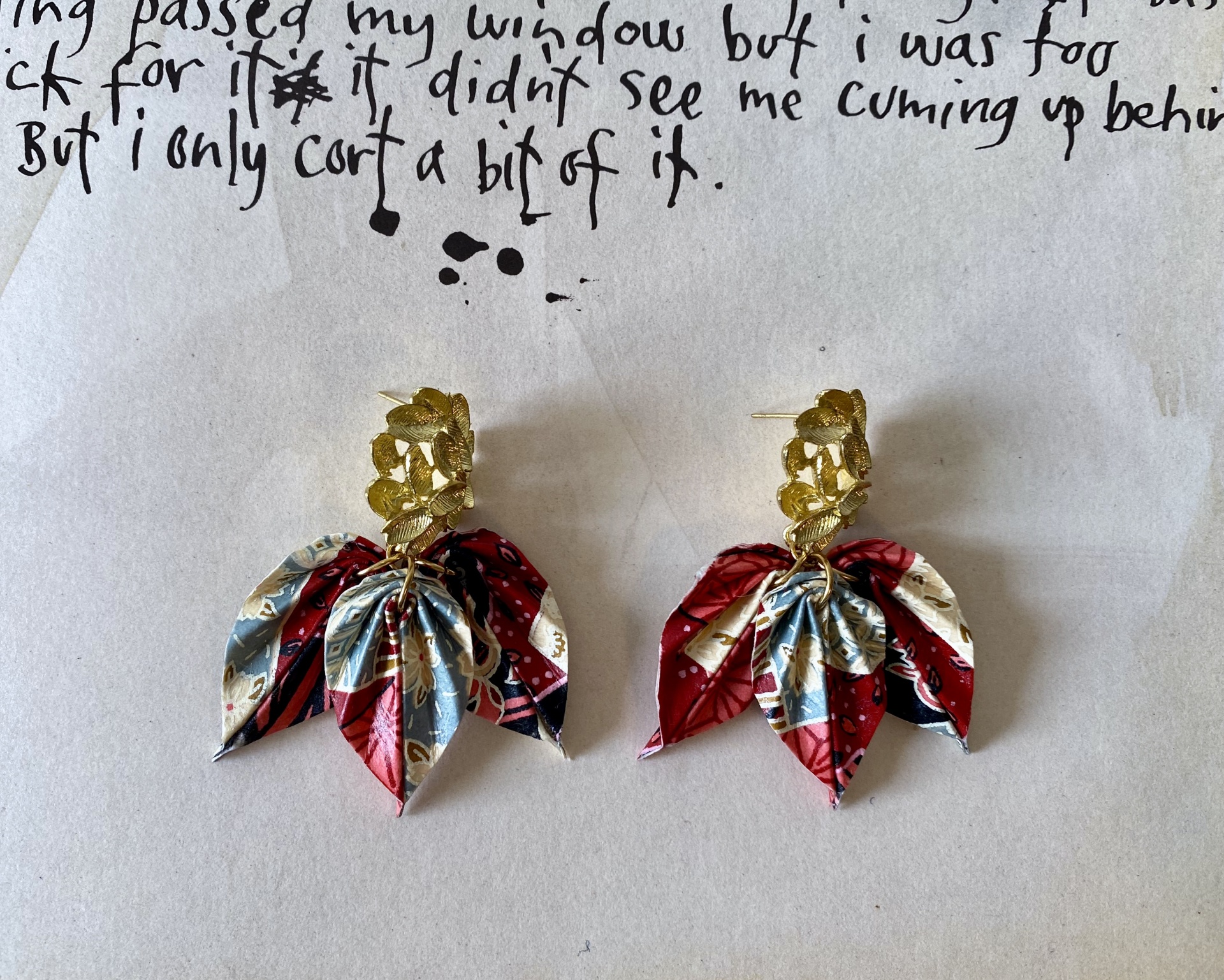 Brincos Folha Brincos de folhas douradas com detalhes em tecido colorido sobre papel manuscrito