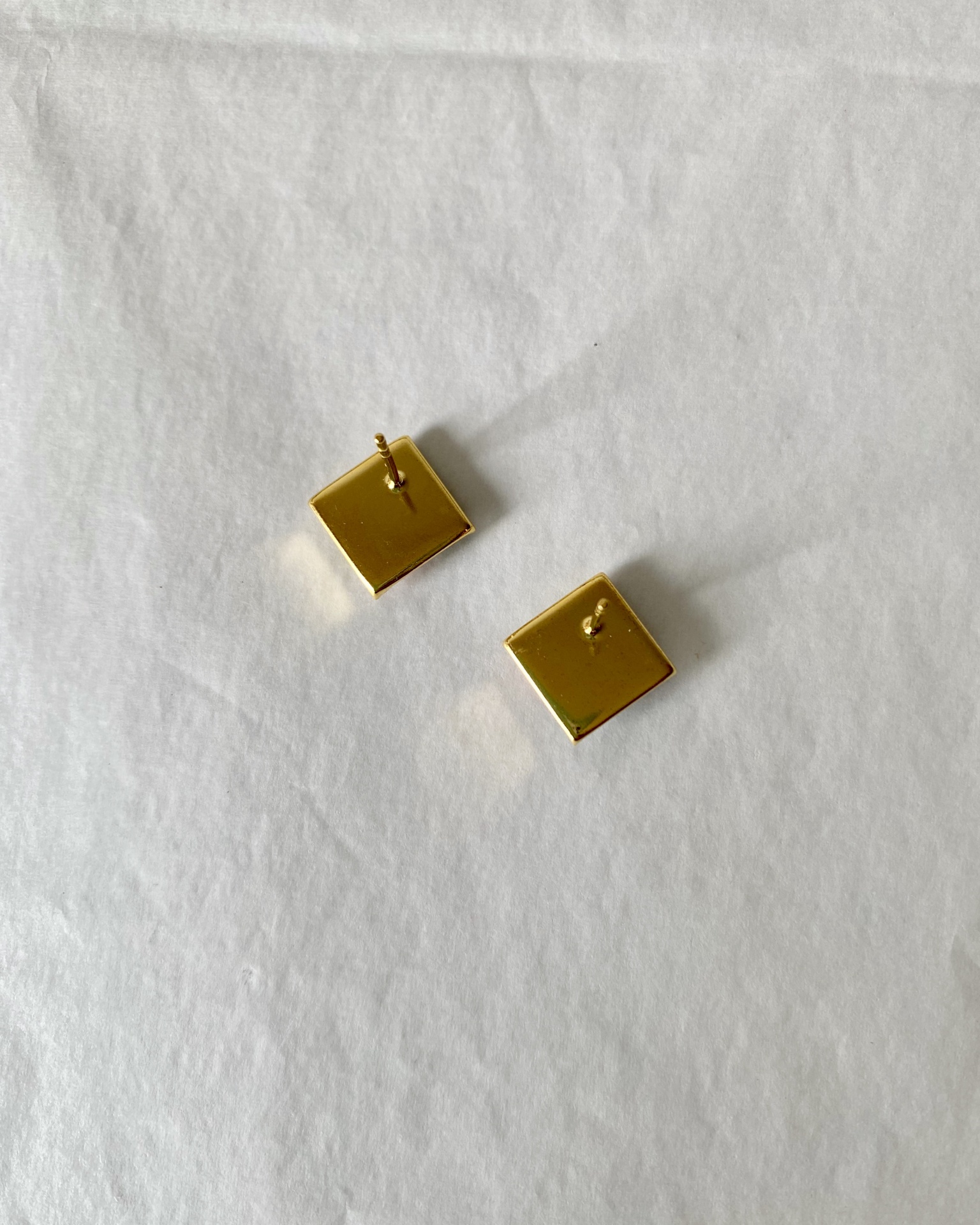 Brincos Menko Clássico Brincos quadrados dourados vistos de trás sobre fundo branco