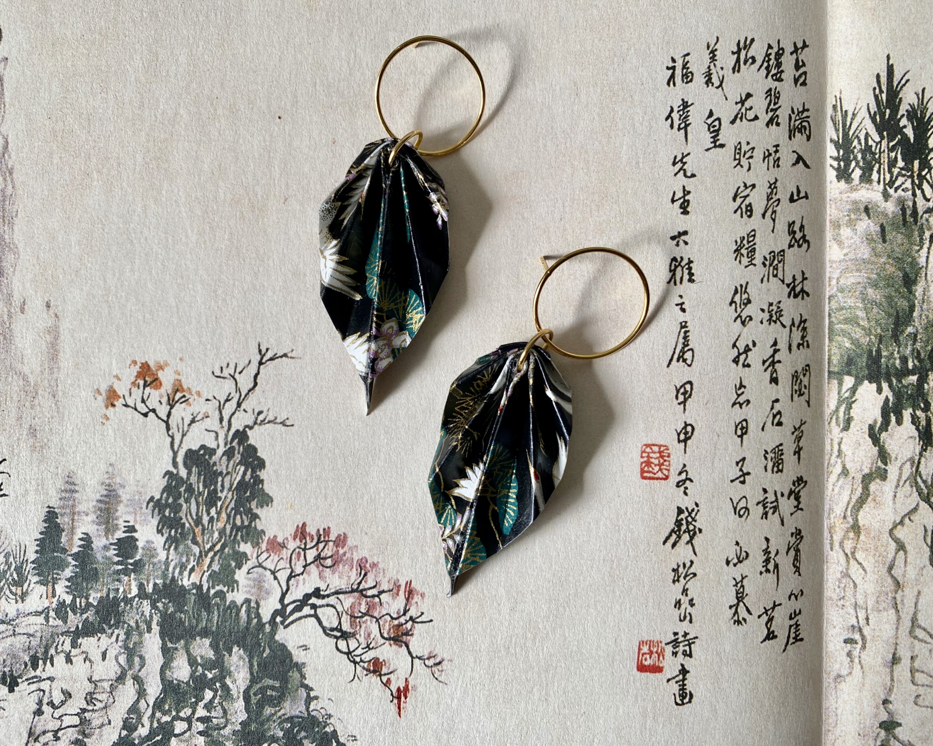 Brincos Folha Brincos com folhas florais em tecido e argolas douradas sobre papel com caligrafia asiática