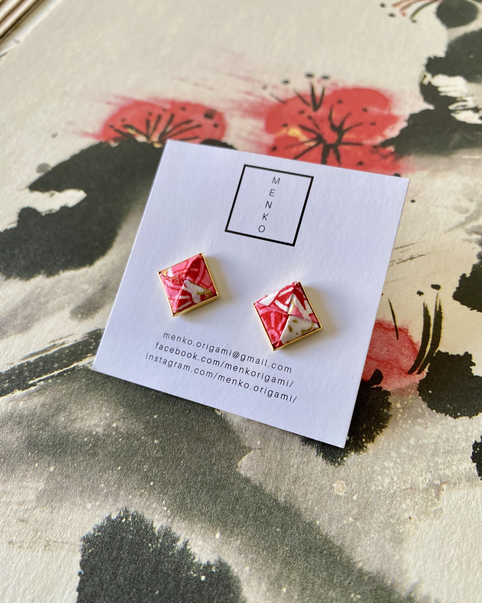 Brincos Menko Clássico Brincos quadrados com padrão vermelho, branco e dourado em cartão branco MENKO