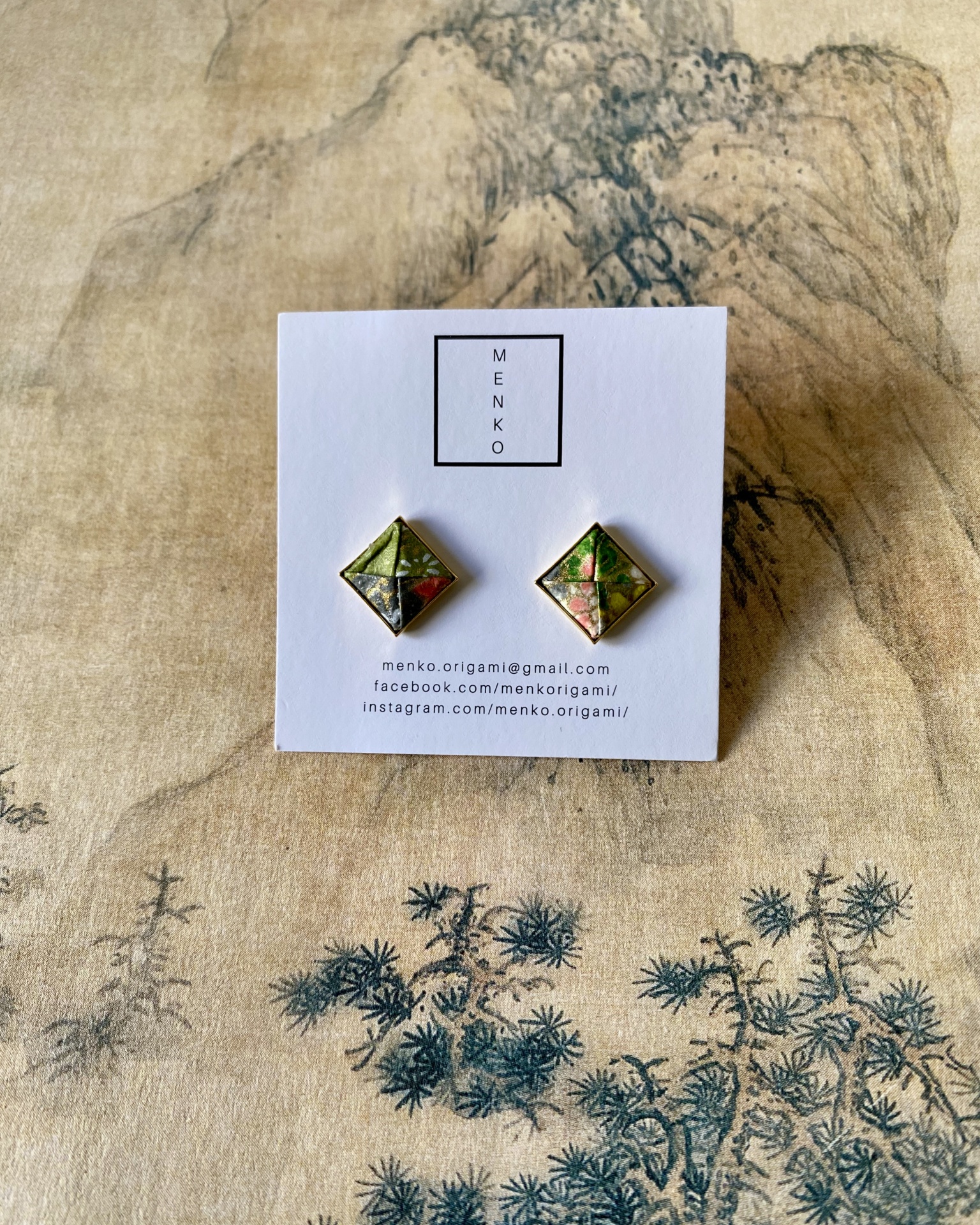 Brincos Menko Clássico Brincos origami quadrados em cartão MENKO sobre tecido estampado