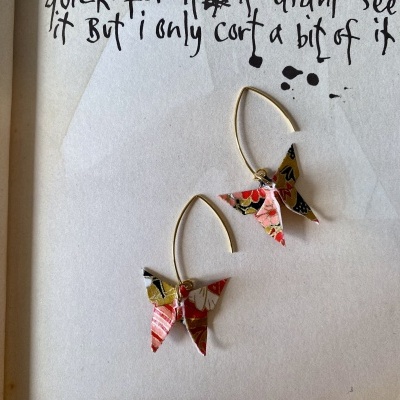 Brincos com borboletas de origami coloridas penduradas em argolas douradas