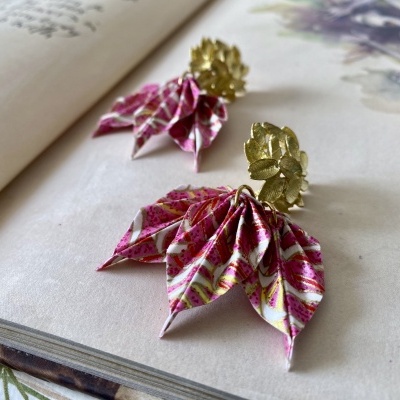 Brincos com tecido colorido e detalhes em metal dourado sobre papel