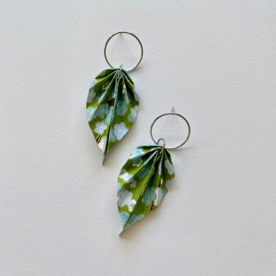 Brincos de tecido verde com padrão de folhas em fundo branco